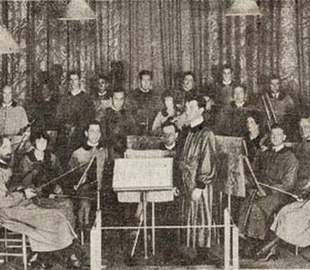 One of the early pictures of the Community Arts String Orchestra in costumes designed by Adele Herter, Roger Clerbois at the conductor’s stand. Concertmaster is Anthony van der Voort; first ‘cello, Harry Kaplun; second ‘cello, Roscoe Lyans; first desk, second violins, Margaret Ellison (now Mrs. Roy C. Beckman of Florida;) behind her is Fred Greenough, violinist; and seated behind her husband is Mrs. Clerbois, violist. The harpist is Mrs. Lyans. An early record of the orchestra personnel says 12 were professionals and the other nine “consisted of two students, a gardener, a taxi driver, a bank president’s wife, a horticulturist, a curio shop keeper and a chemist.”